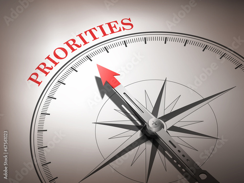 abstract compass needle pointing the word priorities