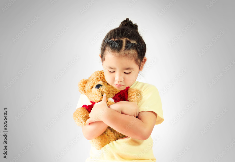 Sad little girl hugging teddy bear alone, studio shoot Sad little girl hugging teddy bear alone, studio shoot