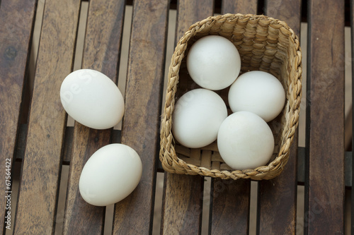 Eggs on wooden table and basket