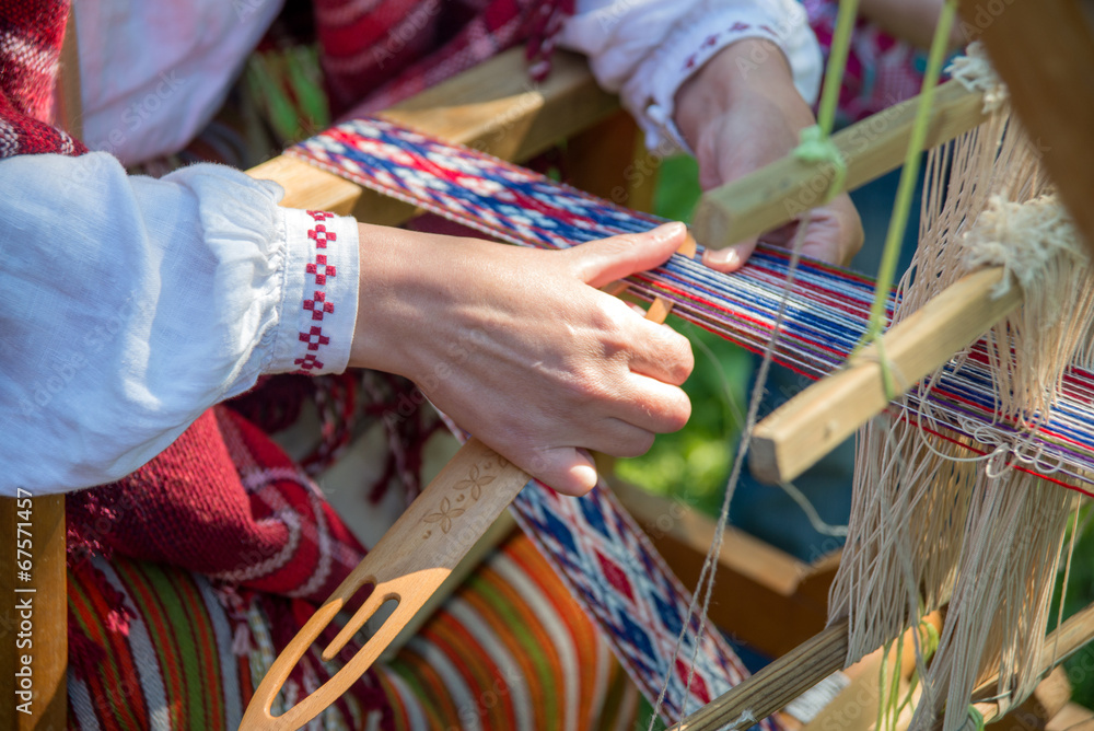 Woman working at the weaving loom. 