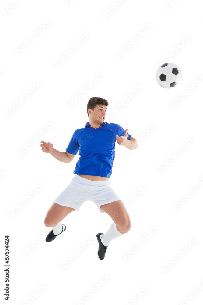 Football player in blue jersey jumping to ball