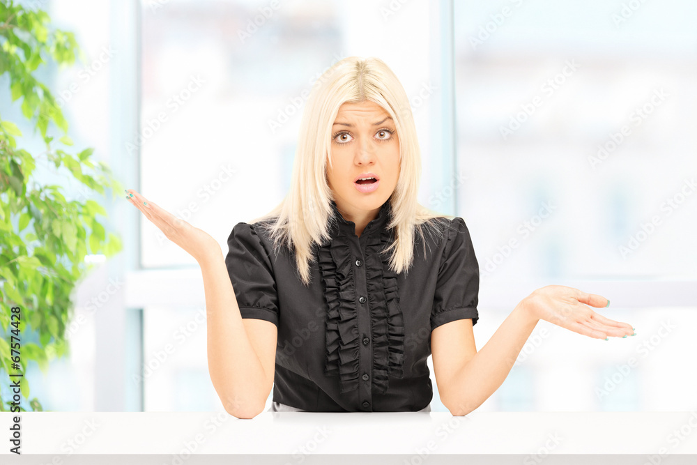 Fototapeta premium Woman gesturing uncertainty seated at home