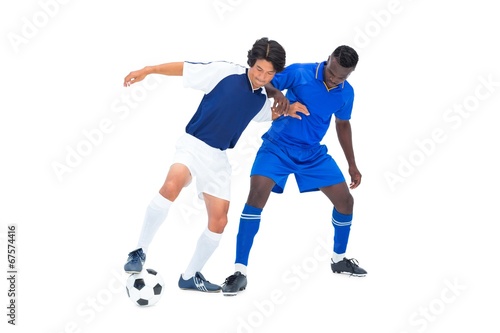Football players tackling for the ball © WavebreakmediaMicro