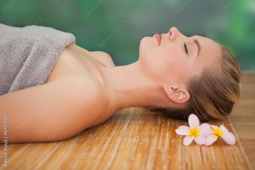Peaceful blonde lying on bamboo mat with flowers - obrazy, fototapety, plakaty 