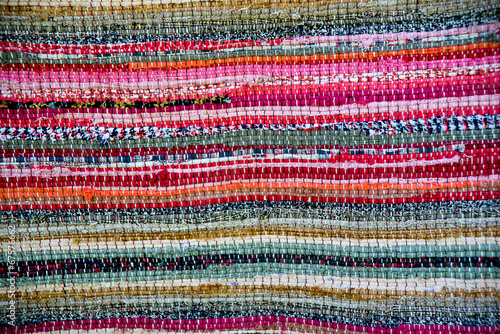 Strip woven colorful rug surface close up. Baltic handmade craft