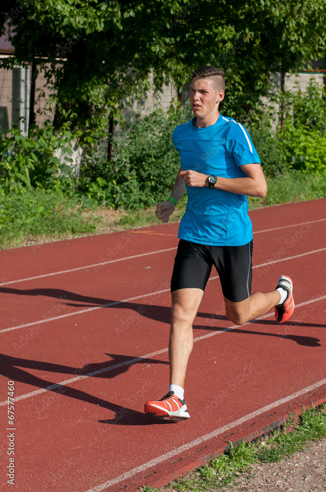 Obraz premium Good looking athlete training on the running track