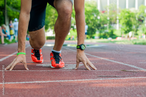 Male athlete waiting at the starting line on the running track