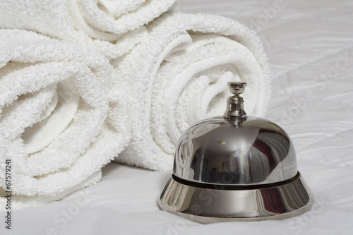 Room service bell and rolled towels.