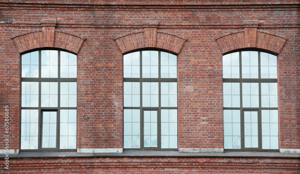 Three window on a red bric wall Three window on a red bric wall