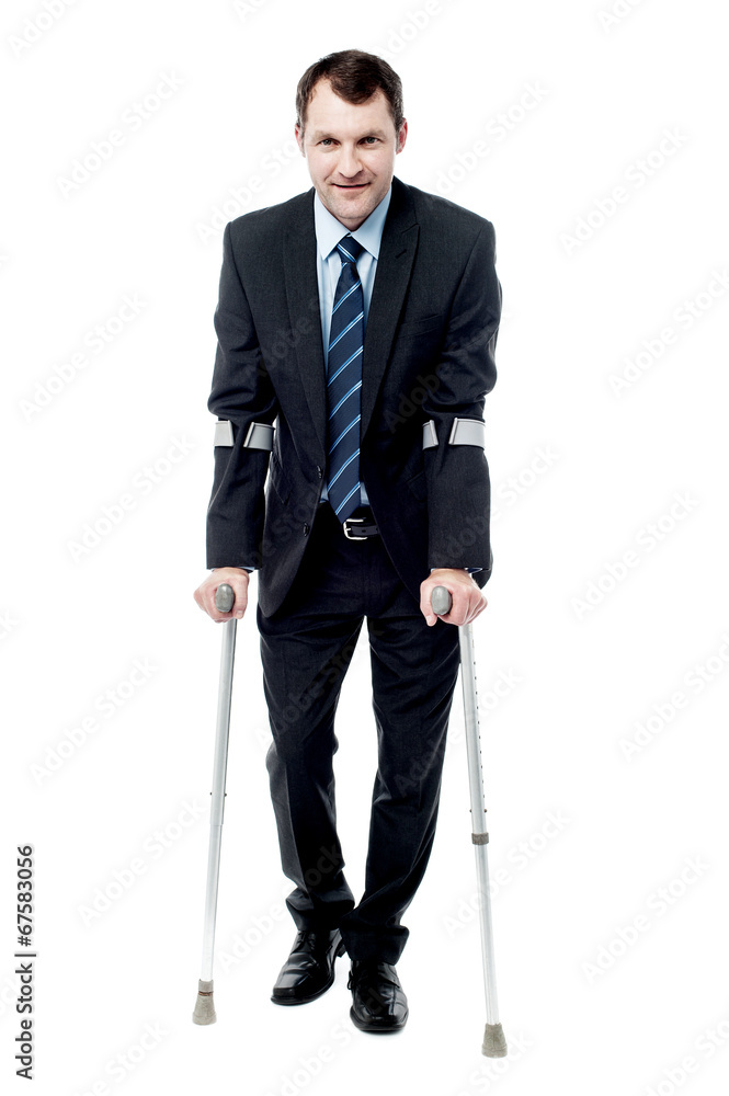 Businessman walking with crutches Businessman walking with crutches