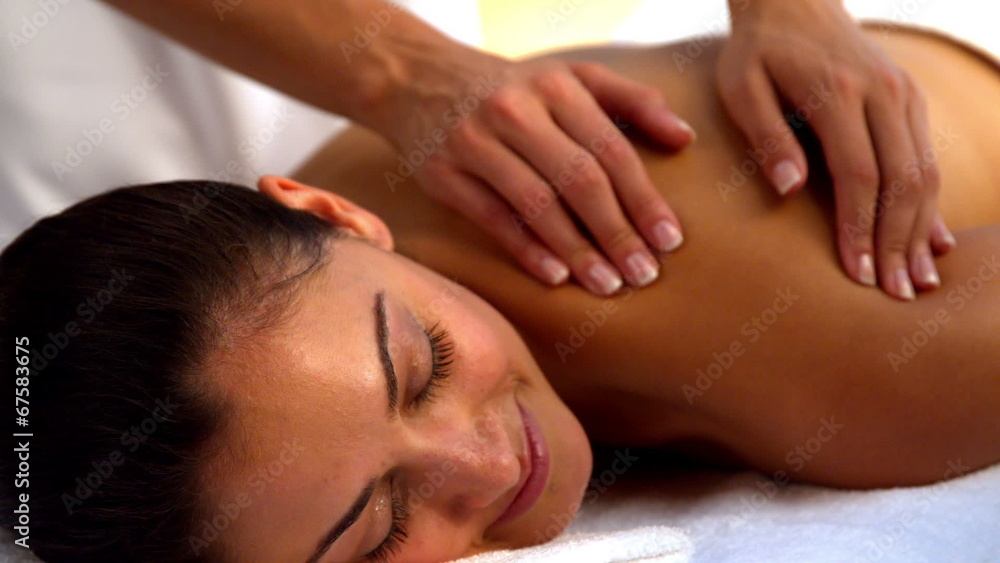 Smiling brunette enjoying a massage at the spa Smiling brunette enjoying a massage at the spa