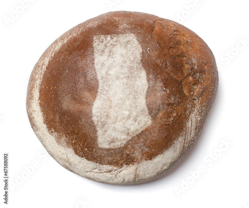 A loaf of fresh bread covered with rye flour in the shape of Gha
