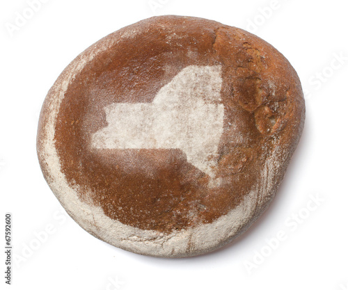 A loaf of fresh bread covered with rye flour in the shape of New