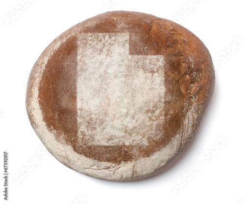 A loaf of fresh bread covered with rye flour in the shape of Uta