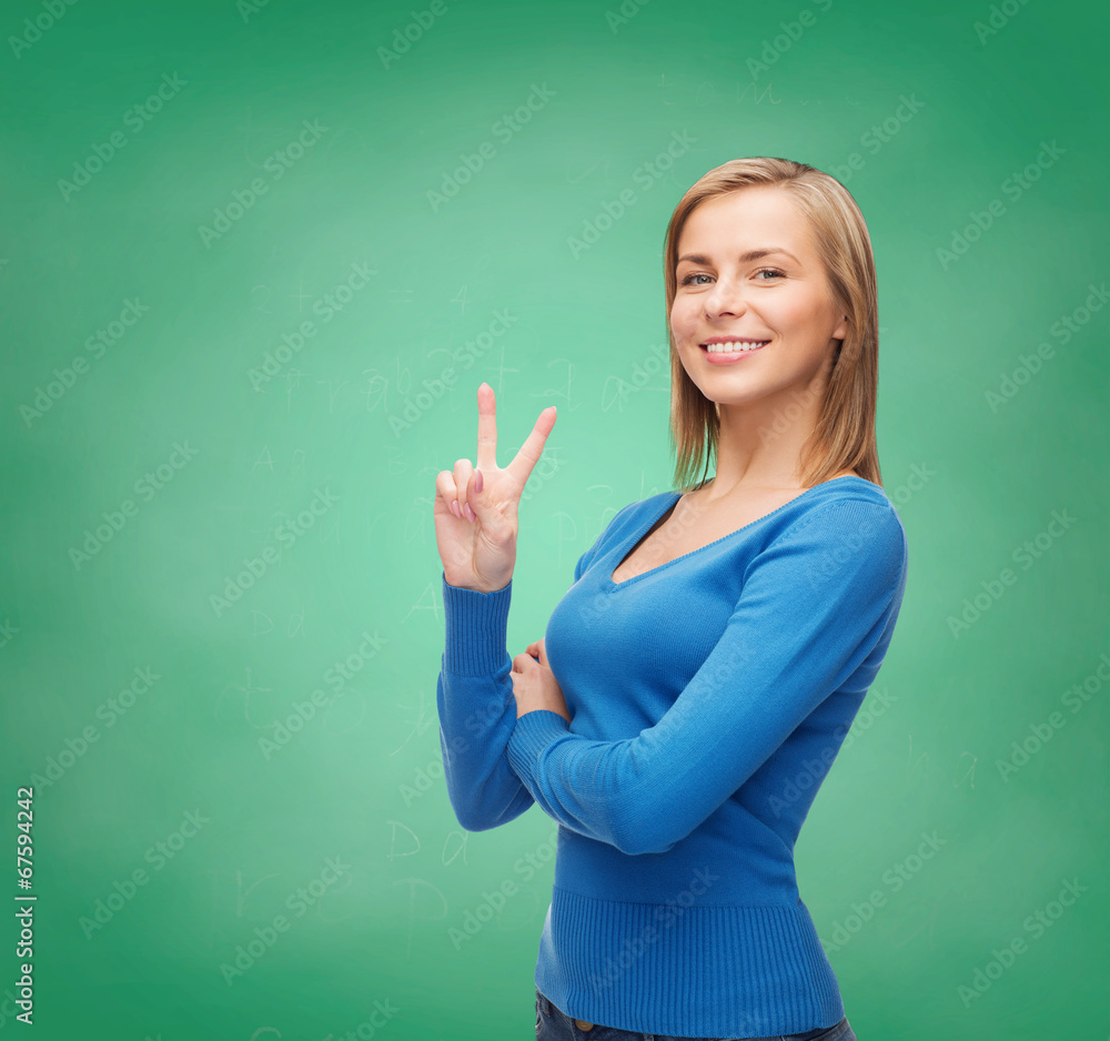 smiling teenage girl showing v-sign with hand smiling teenage girl showing v-sign with hand