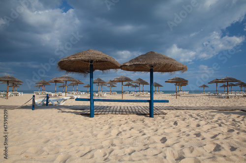 Different parasols and sun loungers on the empty beach on Tavira © Radomir Rezny