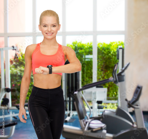 smiling woman with heart rate monitor on hand