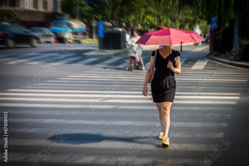 Woman is walking across the street at crosswalk
