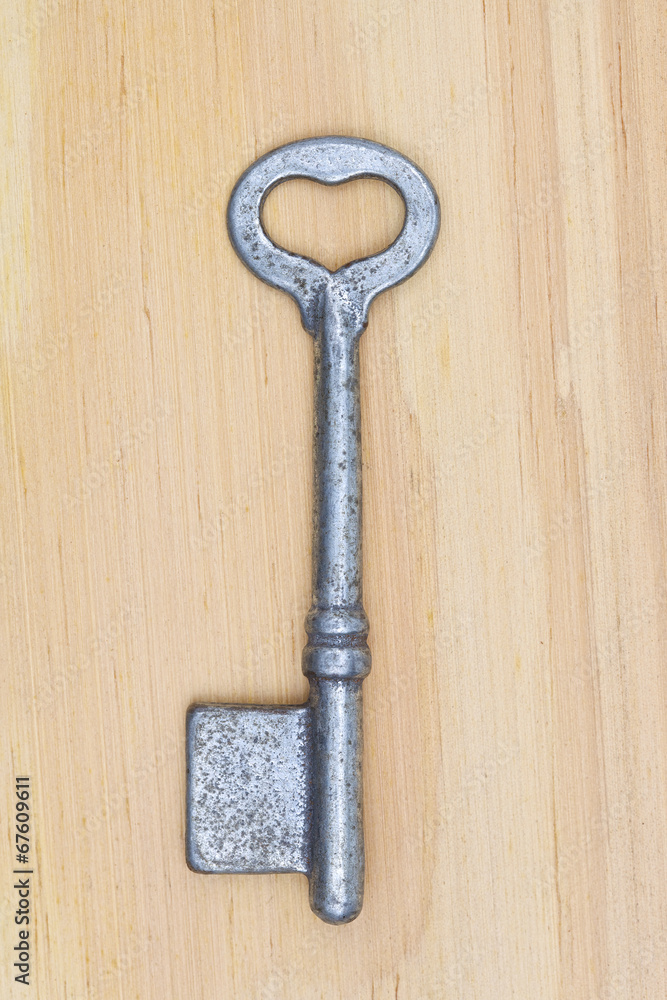 old key with heart shape ring hole on wood texture background old key with heart shape ring hole on wood texture background