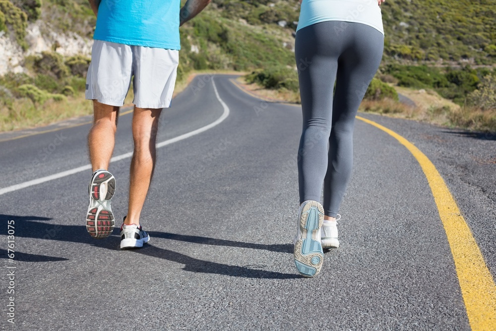 Fit couple running together down a road Fit couple running together down a road