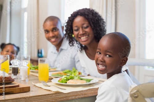 Happy family smiling at camera at lunch