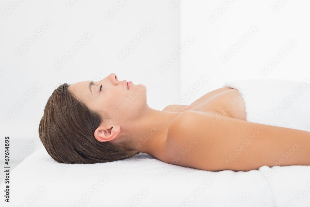 Beautiful woman lying on massage table at spa center Beautiful woman lying on massage table at spa center