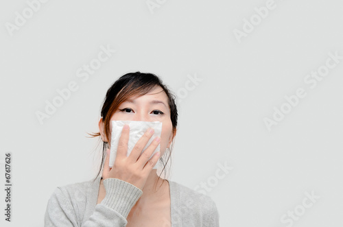 Sick woman blowing her nose isolated.