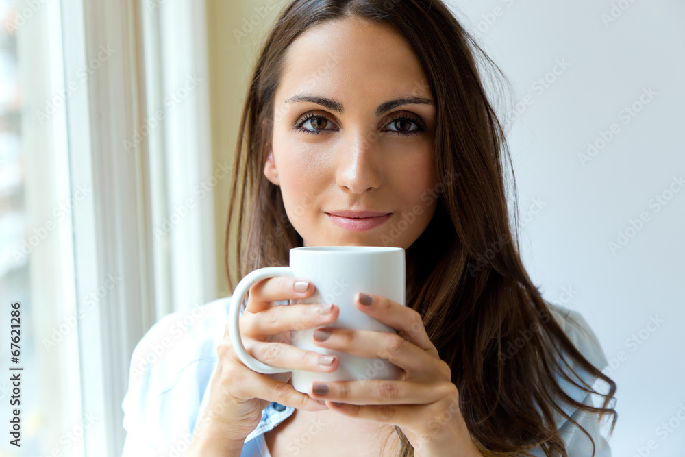Beautiful woman drinking coffee in the morning near the window. Beautiful woman drinking coffee in the morning near the window.