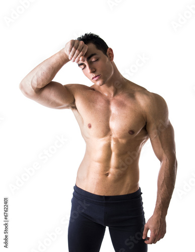 Shirtless muscular male bodybuilder wiping sweat off