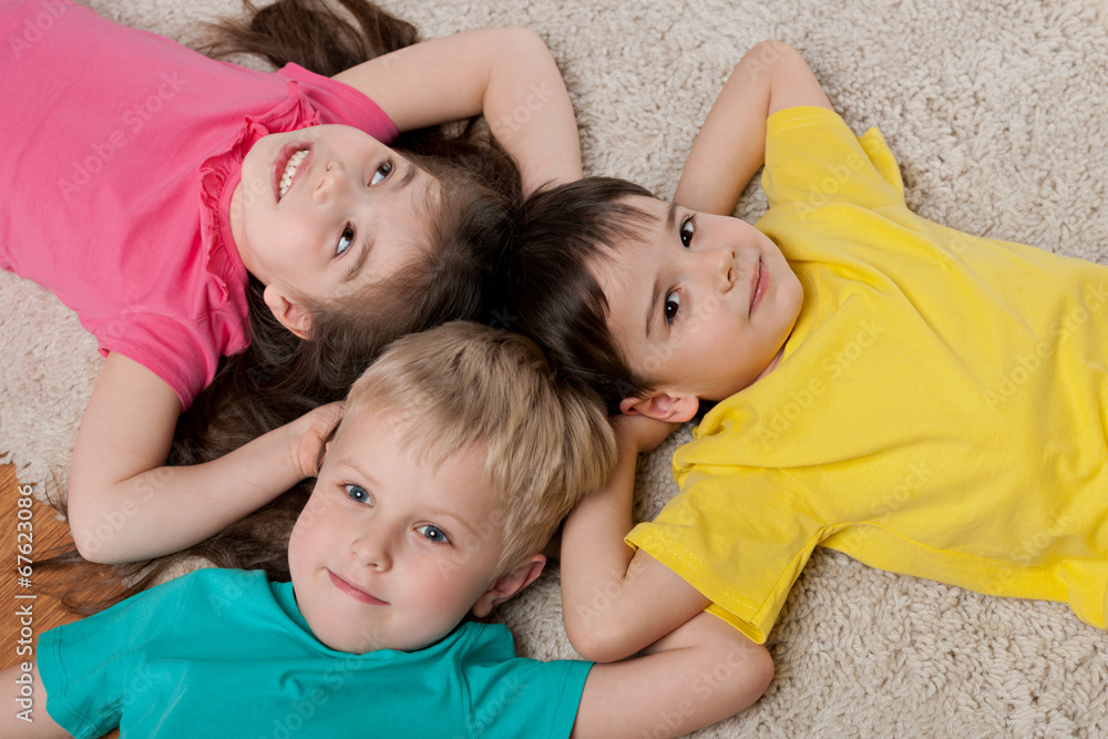 Three happy children on the white carpet