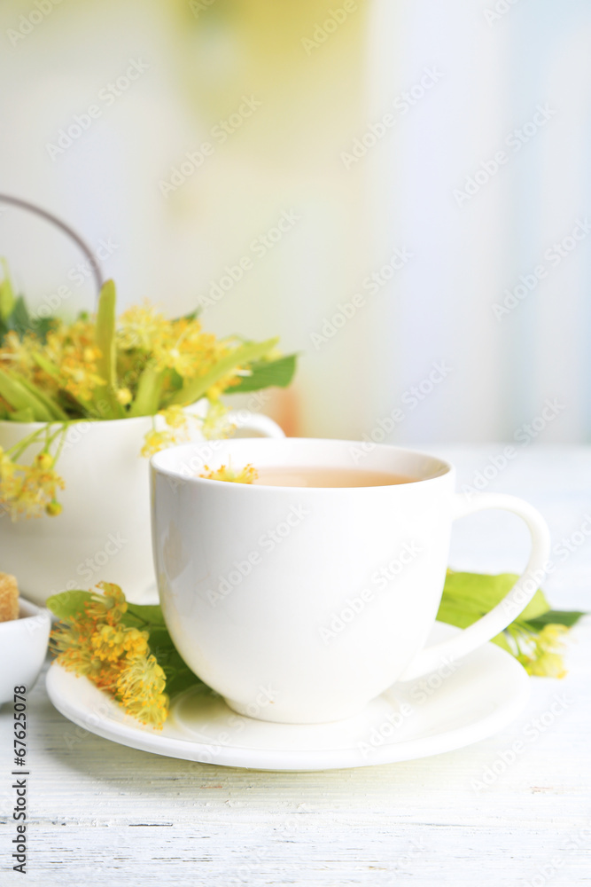 Tasty herbal tea with linden flowers on wooden table Tasty herbal tea with linden flowers on wooden table