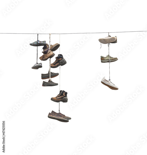 Old worn boots or shoes hang on a cable