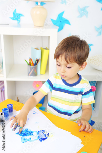 Cute little boy painting in...