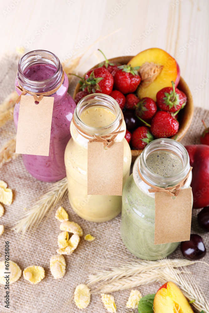 Bottles of delicious smoothie on table, close-up Bottles of delicious smoothie on table, close-up