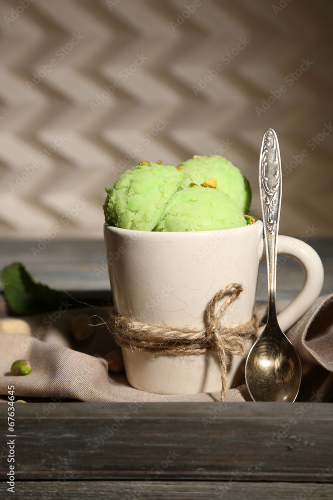 Tasty pistachio ice cream in cup on wooden table Tasty pistachio ice cream in cup on wooden table