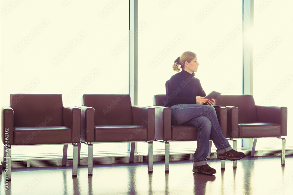 Woman using digital tablet at an airport, office, backlight. Woman using digital tablet at an airport, office, backlight.