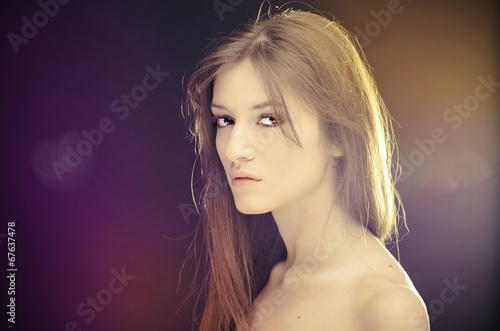 Beautiful Brunette Girl Portrait over Dark Background.