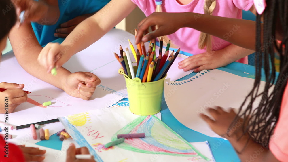 Preschool class drawing at table in classroom
