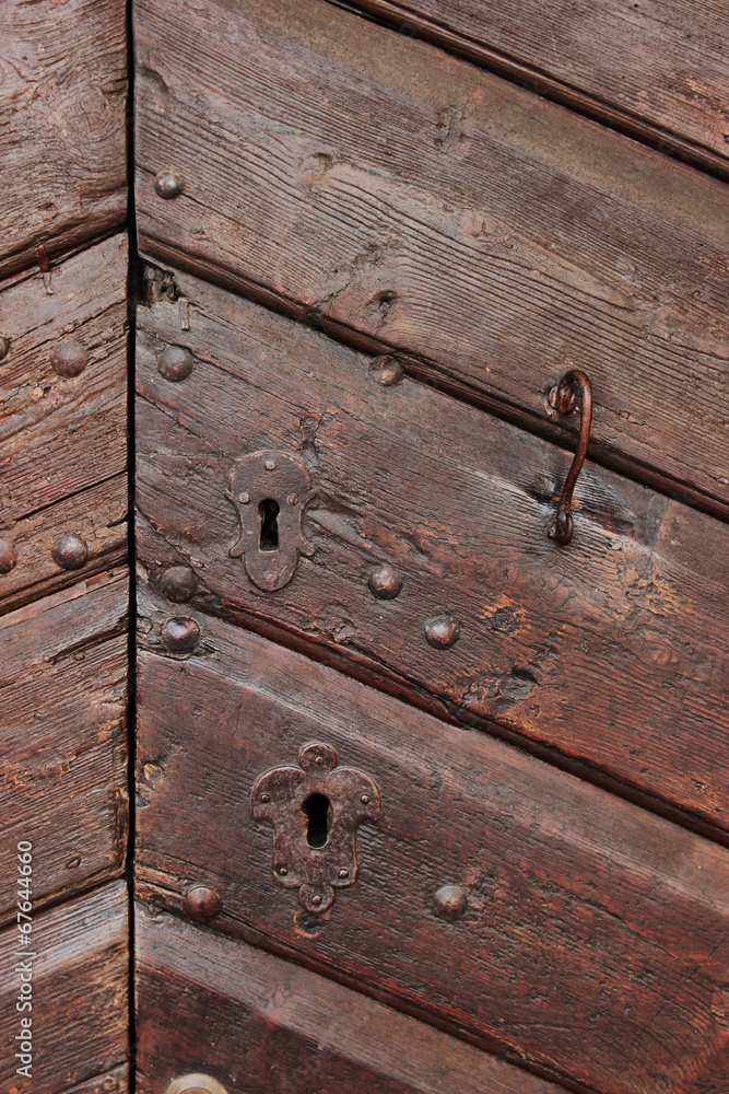 Detail of an old wooden doorway with metal lock and handle