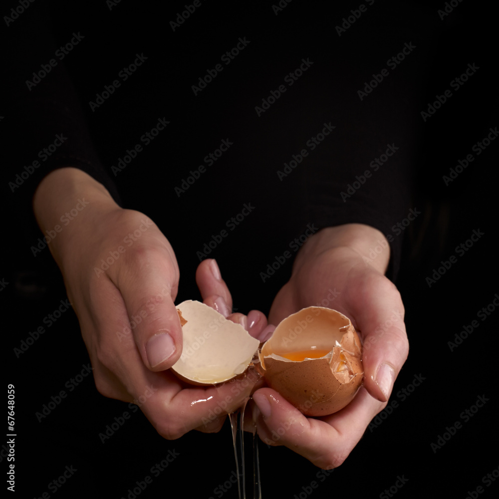 Hands breaking an egg.