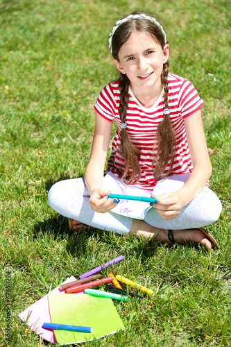 Cute girl drawing in park