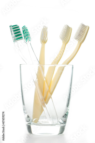 Toothbrushes in glass with whte background