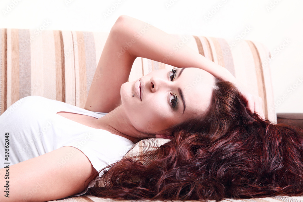 Woman lying on the sofa, long hair, blouse, beautiful hand Woman lying on the sofa, long hair, blouse, beautiful hand