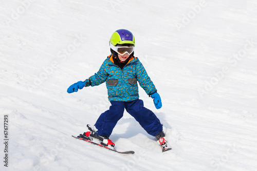 Smiling boy in ski mask learns skiing