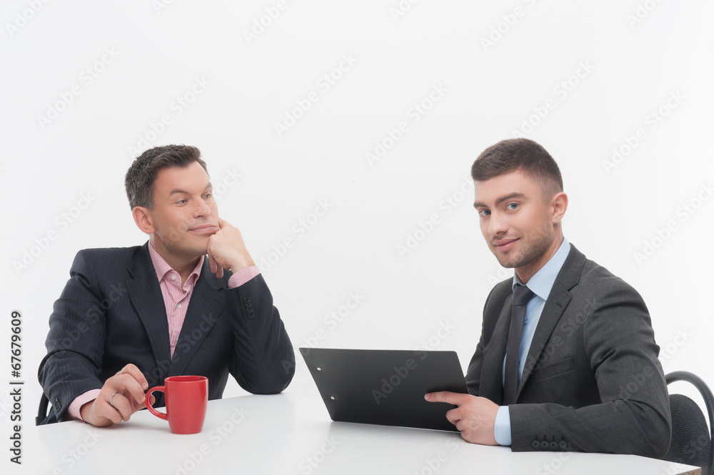 Senior and junior business people discuss something during their Senior and junior business people discuss something during their