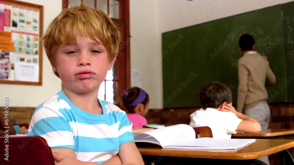 Bored little boy blowing through lips during class Bored little boy blowing through lips during class