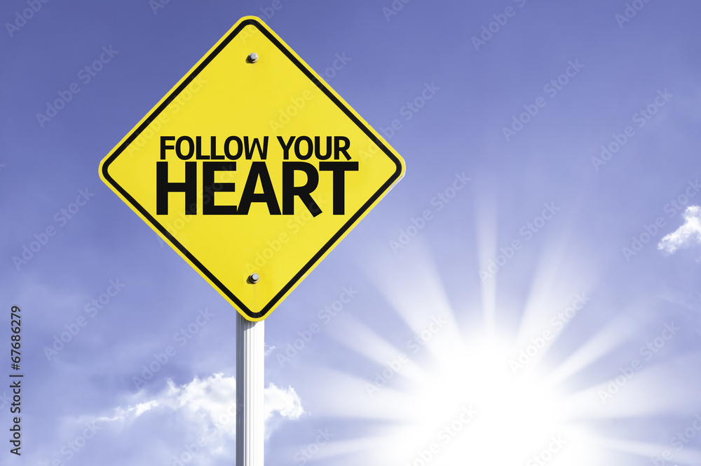 Follow your Heart road sign with sun background Follow your Heart road sign with sun background