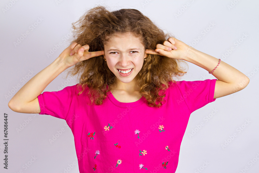 Unhappy stressed girl covering ears from loud noise Unhappy stressed girl covering ears from loud noise