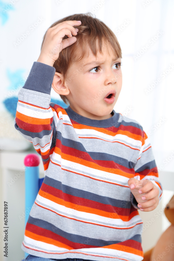 Cute little boy sitting on small chair in room Cute little boy sitting on small chair in room