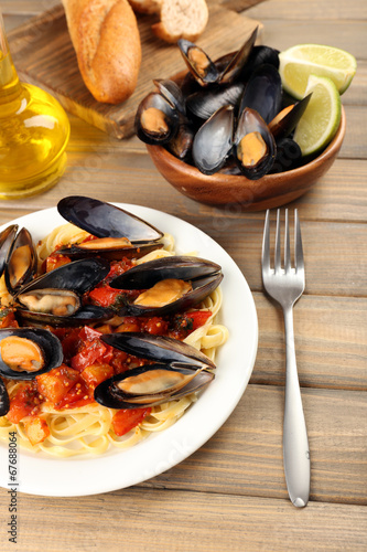 Tasty noodles with mussels on table, close up